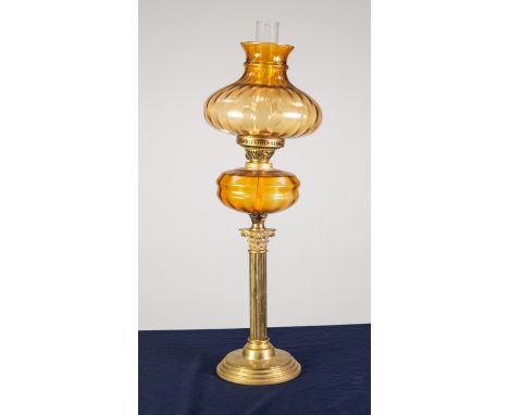 BRASS CORINTHIAN COLUMN PATTERN OIL TABLE LAMP, with circular, stepped base, moulded amber glass reservoir and shade, and chi