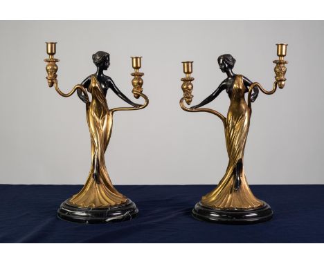 A PAIR OF TWENTIETH CENTURY POLISHED AND DARK LACQUERED BRASS TWIN BRANCH FIGURAL CANDELABRA on circular veined black marble 
