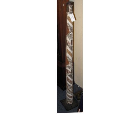 Australian didgeridoo with painted decoration on metal stand.