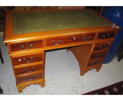 Reproduction yew wood pedestal desk with leather inset top.