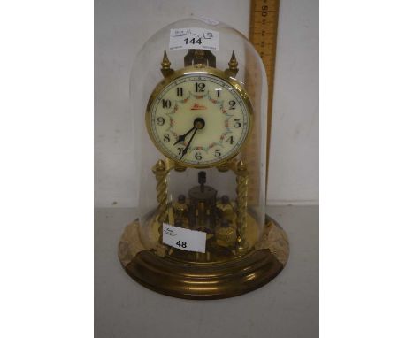 A brass anniversary clock under glass dome