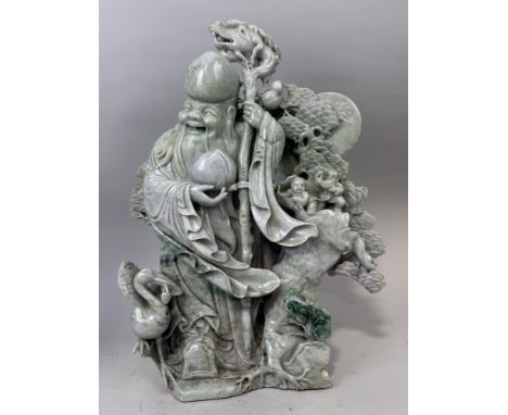 A CHINESE JADE OR JADEITE SCULPTURE DEPICTING THE LUOHAN WITH A DRAGON STAFF, CHILDREN, CRANES AND FOLIAGE IN THE BACKGROUND5