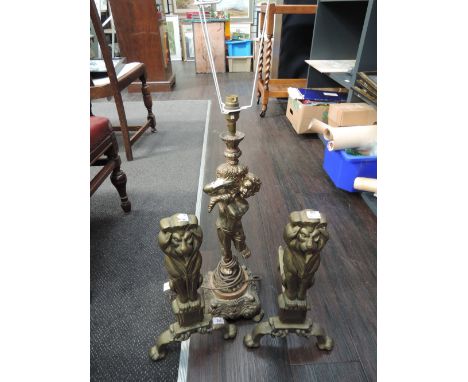 Two brass fire dogs and a gilt effect cherub lamp