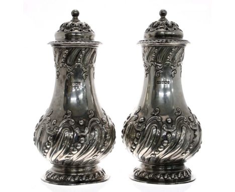 Good pair of late Victorian silver sugar casters, of wrythen fluted baluster form with scrolling repousse decoration and scre