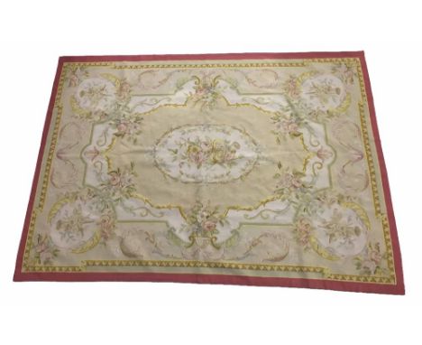 Aubusson type rug, the central oval foliate panel within multiple floral swag borders, on a natural ground, within a deep red