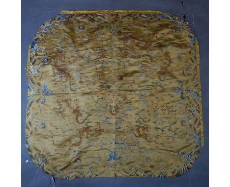 A late 19th/early 20th century Chinese silk panel, decorated with dragons amongst stylised waves, with gold and silver thread