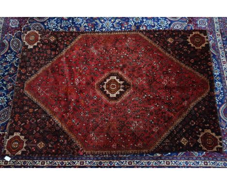 A Persian Qashqai carpet with geometric motifs, on a red ground, contained by geometric border, 256 x 170cm 