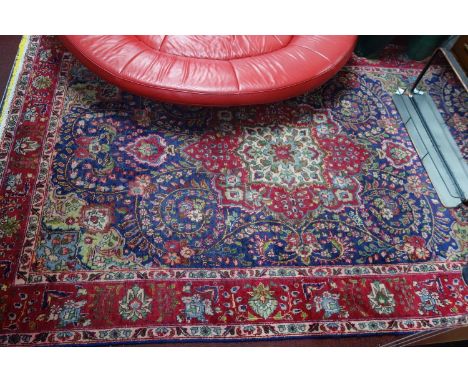 A Persian Tabriz carpet, the central floral medallion surrounded by floral motifs, on a blue ground, contained by floral bord