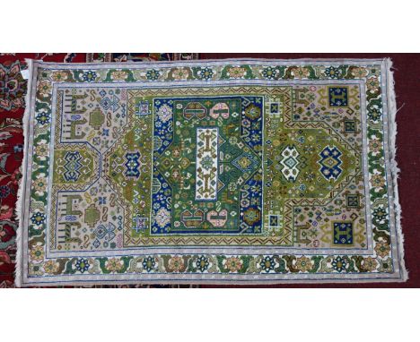 A part silk Persian Kirman rug, geometric and animal motifs on a light pink/cream ground, within floral borders and bands, 15