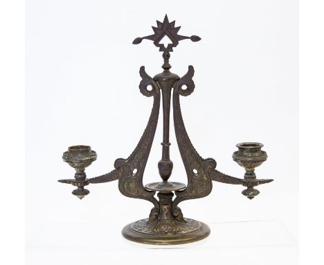 Christopher Dresser (attributed), a cast metal two branch candelabrum, circa 1870, decorated in relief with Aesthetic Movemen
