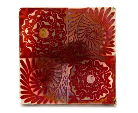 William De Morgan, a red lustre tile, quartered into alternating Tudor rose and foliate spirals, iridescent red on cream grou