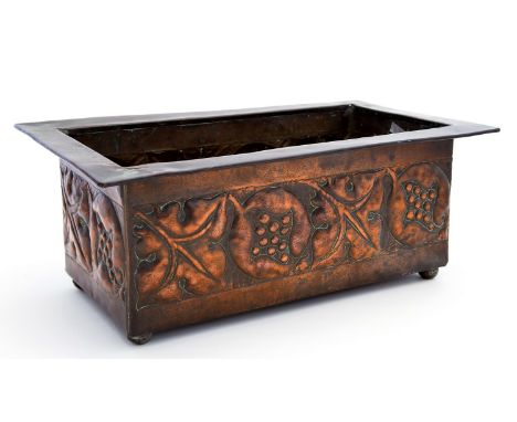 An Arts and Crafts copper rectangular planter, repousse decorated with leaf and pomegranate design to all four sides, in the 