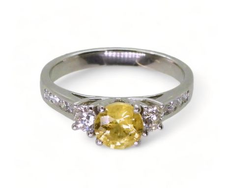 A platinum, yellow sapphire and diamond ring, set with a 6mm round cut sapphire, and 0.50cts of brilliant cut diamonds, finge