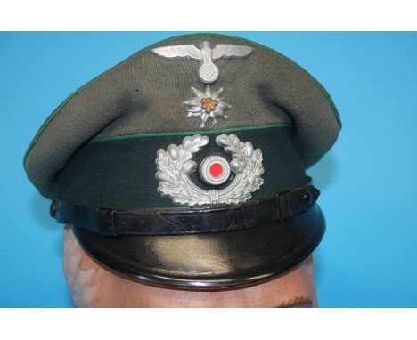 A German Gebirgstruppe (Mountain Troop) Non-Commissioned Officer's (NCO) visor cap, with metal eagle, swastika badge, Edelwei