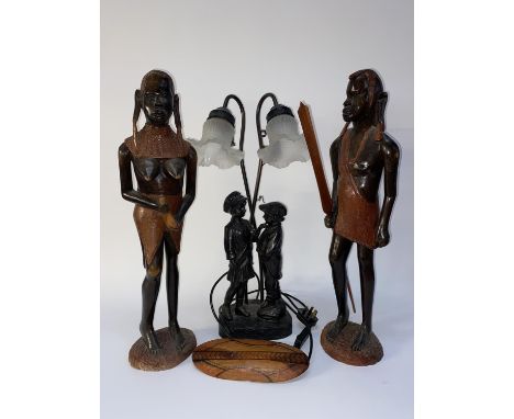 A bronze effect figural table lamp, H 60cm and two African hardwood Warrior studies