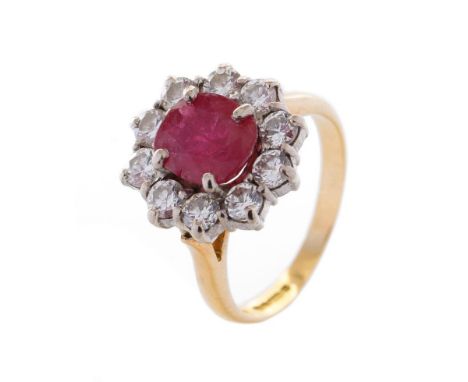 An 18ct yellow gold ruby and diamond cluster ring, with central oval-cut ruby and border of ten round brilliant-cut diamonds,