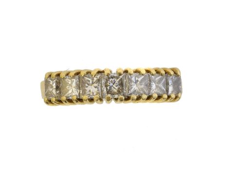 An 18ct gold diamond seven stone ring. The princess cut diamond line with polished shoulders, estimated total diamond weight 