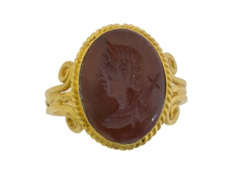 A carnelian intaglio ring. The oval intaglio depicting a classical bust, within a yellow metal setting, ring size K, gross we