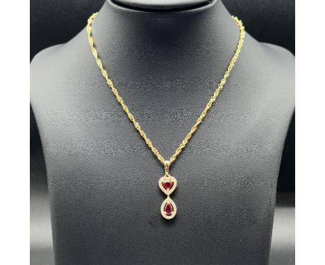 An 18ct yellow gold ruby + diamond pendant, comes with a 9ct yellow gold chain 24 inches in length, pendant is 32mm x 10mm, t