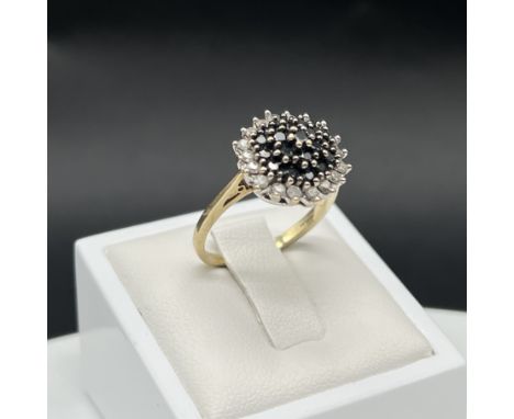 A 9ct yellow gold black + white diamond cluster ring, size O, 4 grams in weight approx