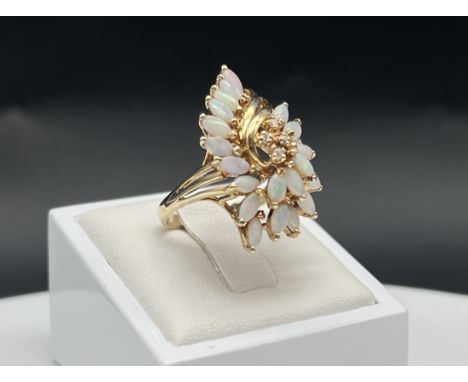 A 14ct yellow gold opal + diamond dress ring,
size P,
6.1 grams in weight approx,
set with 21 marques cut style opal stones a