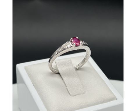 18ct white gold ruby and diamond ring,oval cut ruby,5mm x 3mm ruby,set with diamonds on the shoulders,size N,3.3 grams,excell