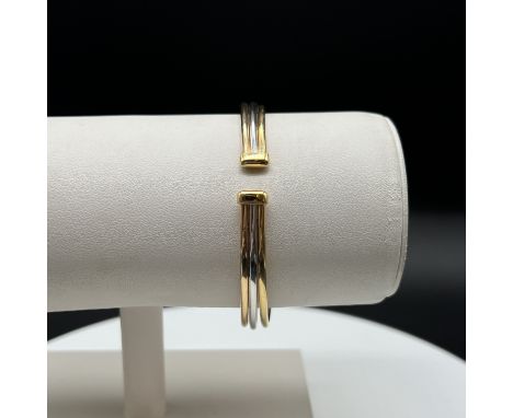 An 18ct tricoloured gold bangle, 11.5 grams in weight approx, 6mm wide, 