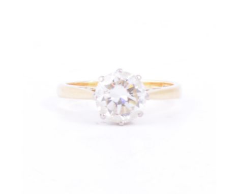 A diamond solitaire ring, the brilliant cut stone claw set in an 18 carat yellow and white gold mount with spear point and tu