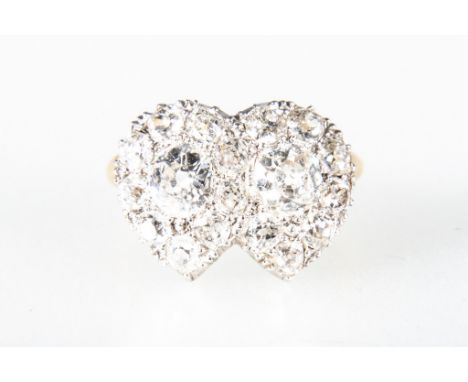 A diamond heart design cluster ring, the two connected hearts having an old cut diamond to the centre of each surrounded by s