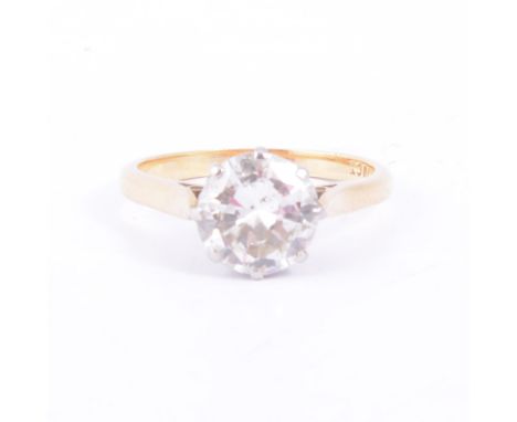 A diamond solitaire ring, the brilliant cut stone claw set in a yellow and white gold mount, 2mm wide shank with spear point 