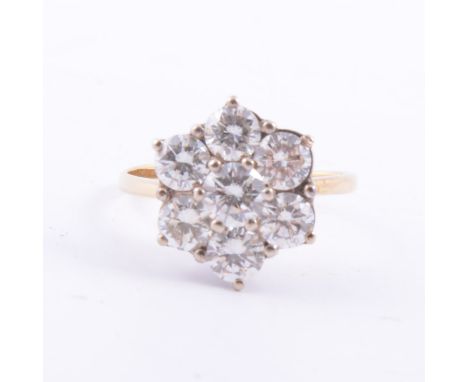 A diamond floral cluster ring, seven brilliant cut diamonds claw set in a yellow and white metal mount, 1.5mm wide yellow met