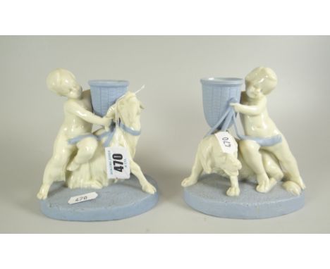 A PAIR OF ROYAL WORCESTER PORCELAIN MODELS OF PUTTI with spillholder vases, one accosting a goat, the other with large dog, b
