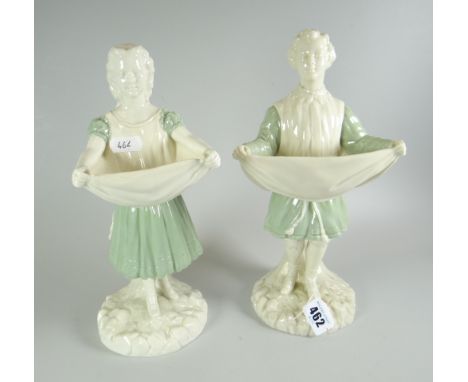 A PAIR OF ROYAL WORCESTER FIGURES in the form of a court entertainer lifting his cloak at the front to form a dish, together 