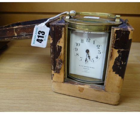 CARRIAGE CLOCK in brass and of oval shape raised on four feet with French movement, the dial marked with retailer CJH Brown &