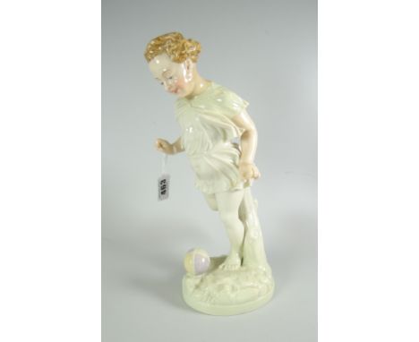 AN IRRIDESCENT PORCELAIN FIGURE OF A CHILD KICKING A FOOTBALL on a naturalistic base in the manner of Royal Worcester (umarke