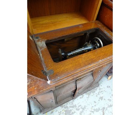 A VINTAGE SINGER TREADLE SEWING MACHINE in a wooden case together with various contents