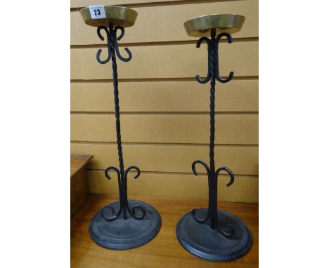 TWO SIMILAR CAST IRON SCROLL AND SPIRAL DESIGN CANDLESTICK HOLDERS