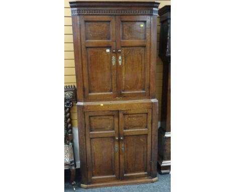 ANTIQUE OAK TWO SECTION BLIND PANEL CORNER CUPBOARD, both sections revealing fitted shaped shelves 210 cms high x 94 cms wide