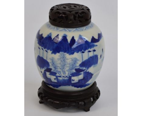 A 19th century Chinese ginger jar with hardwood cover and stand, painted in underglaze blue with architectural and mountainou
