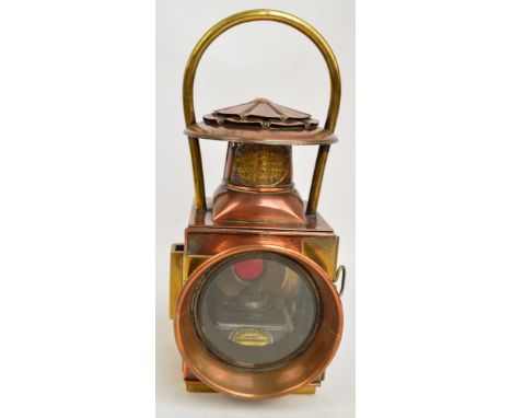 A Shand Mason & Co copper and brass fire engine lamp with clear glass lens to the front and red tinted glass to the back, wit