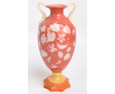 A Locke & Co Worcester pâte-sur-pâte coral and white twin handled footed vase of urn form, the shaped foot probably associate