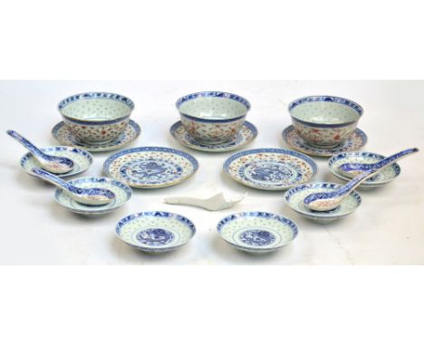 A set of three Chinese bowls and covers with saucers and spoons, with rice decoration, painted in underglaze blue and with re