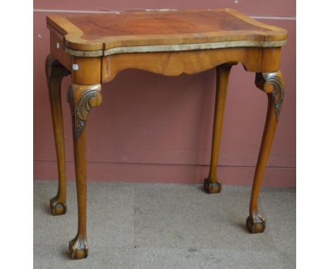 An early 20th century Queen Anne style burr walnut and walnut crossbanded foldover card table raised on four supports to paw 