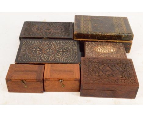 A collection of seven trinket boxes including a pine simulated strap inlaid example, four carved examples and two small teak 