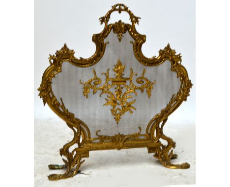 An early 20th century brass and mesh firescreen in the French taste with foliate scroll frame, height 78cm. CONDITION REPORT: