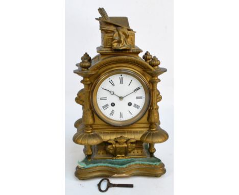 A late 19th century French gilt metal eight day mantel clock, the circular enamel dial set with Roman numerals above a coat o