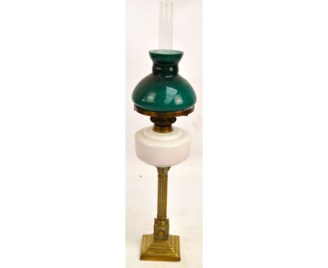 A small Edwardian oil lamp with white glass reservoir raised on Corinthian column to stepped square base, with green glass sh