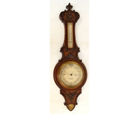 An Edwardian carved oak banjo barometer/thermometer, the circular dial inscribed "J. Casartelli & Son, 43 Market Street, Manc