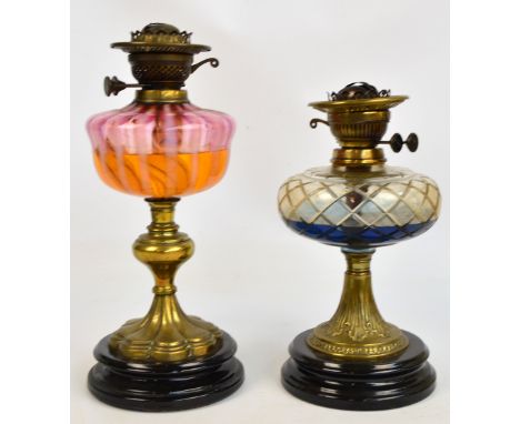 A late Victorian oil lamp with brass stem, circular base and two tone glass reservoir, height 43cm, and a  further example wi