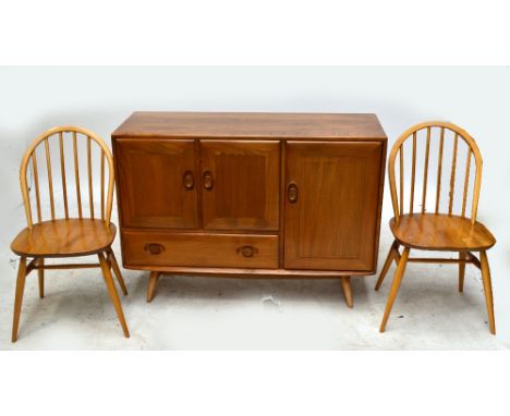 An Ercol elm sideboard, three stick back chairs and a rounded rectangular table (5).